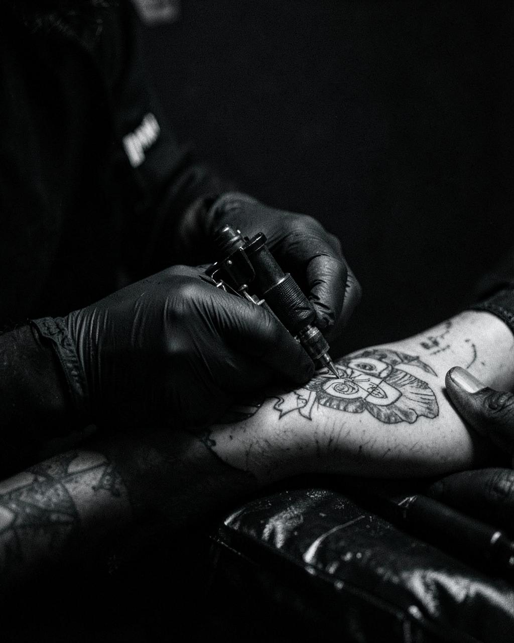 Tattoo artist at Tattoo Me shading a black and grey forearm tattoo
